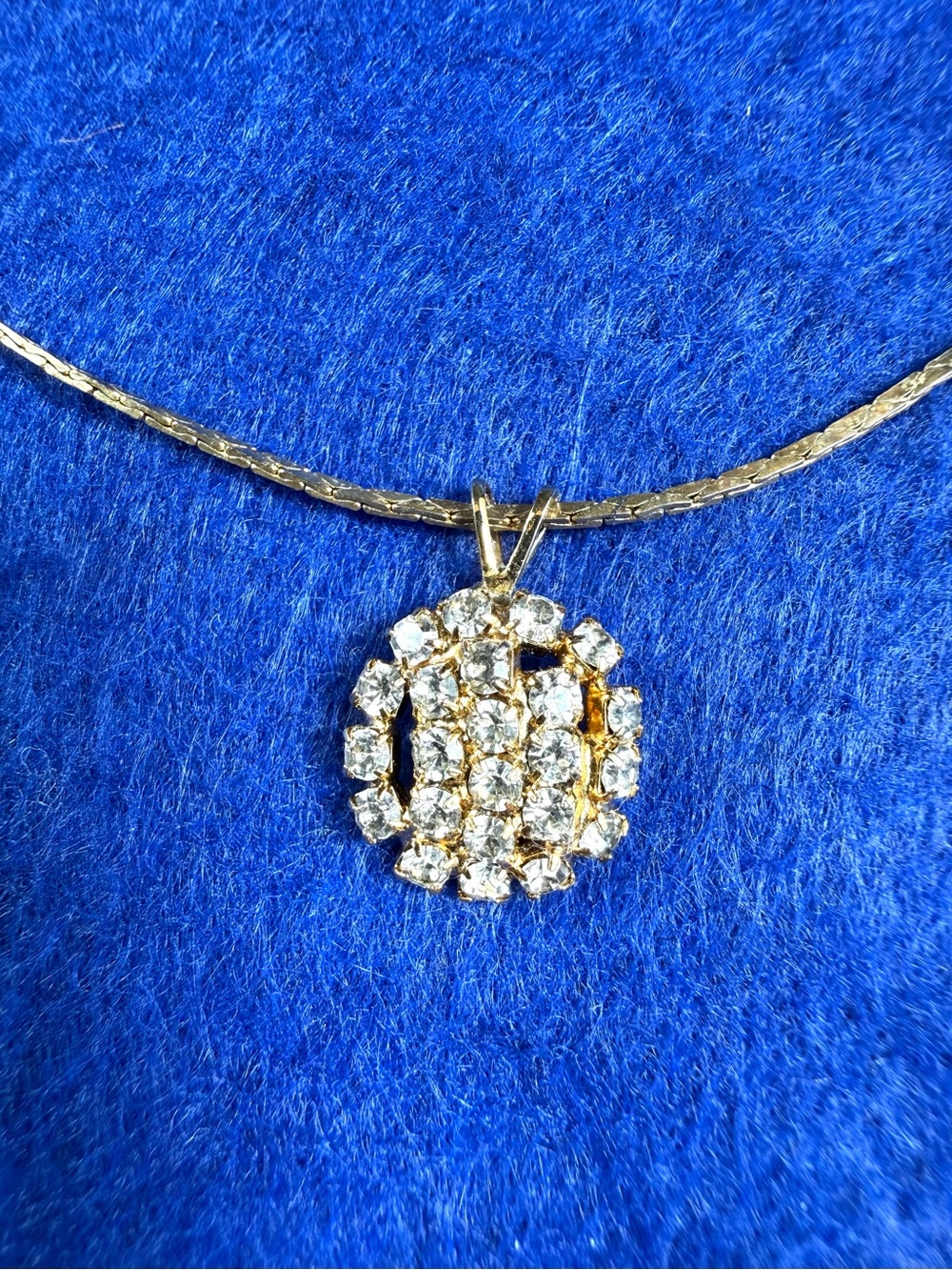 Gold tone and rhinestone pendant necklace.